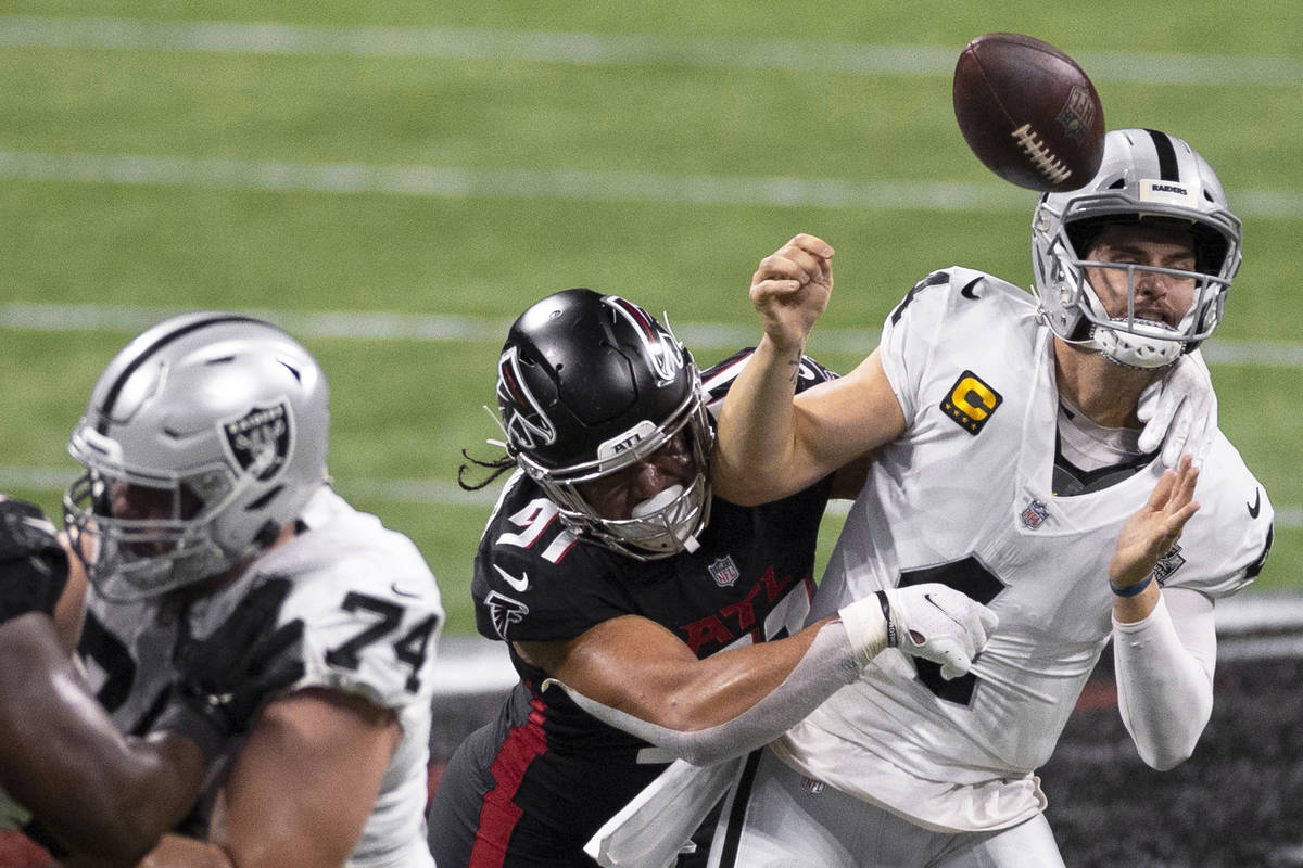 Las Vegas Raiders quarterback Derek Carr (4) is strip sacked by Atlanta Falcons defensive tackl ...