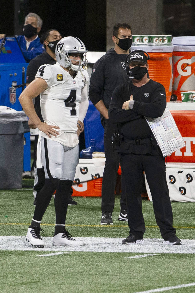 Las Vegas Raiders quarterback Derek Carr (4) and head coach Jon Gruden look on from the sidelin ...