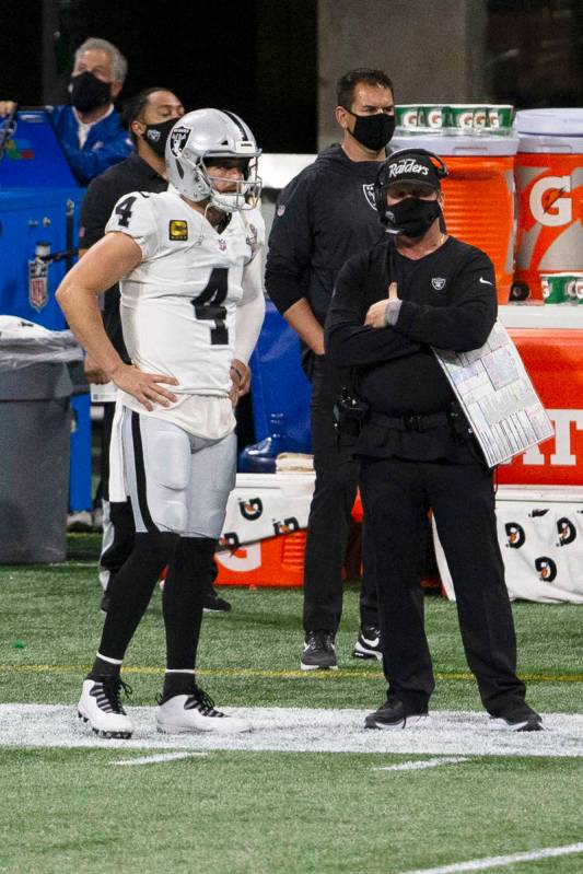 Las Vegas Raiders quarterback Derek Carr (4) and head coach Jon Gruden look on from the sidelin ...