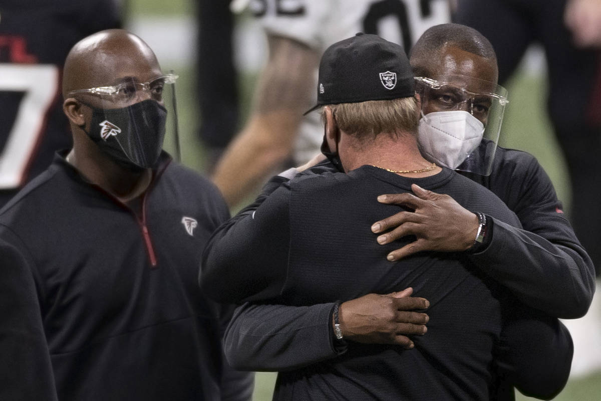 Atlanta Falcons head coach Raheem Morris, right, hugs Las Vegas Raiders head coach Jon Gruden a ...
