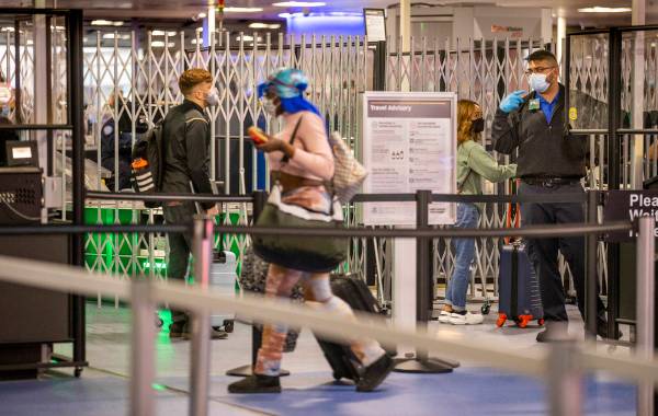 Travelers make their way through the TSA checkpoint at Terminal 1 during holiday travel at McCa ...