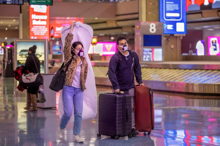 Erica Lee, left, and fiance Robert Izuta of Omaha make their way through bag at Terminal 1 on t ...