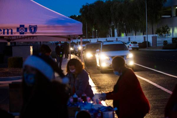 Families line up for a charity drive-thru event at Metro's Bolden Area Command substation in La ...