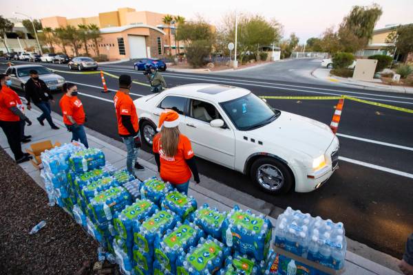 Volunteers with Home Depot deliver cases of water along with meals, holiday decorating kits, ha ...
