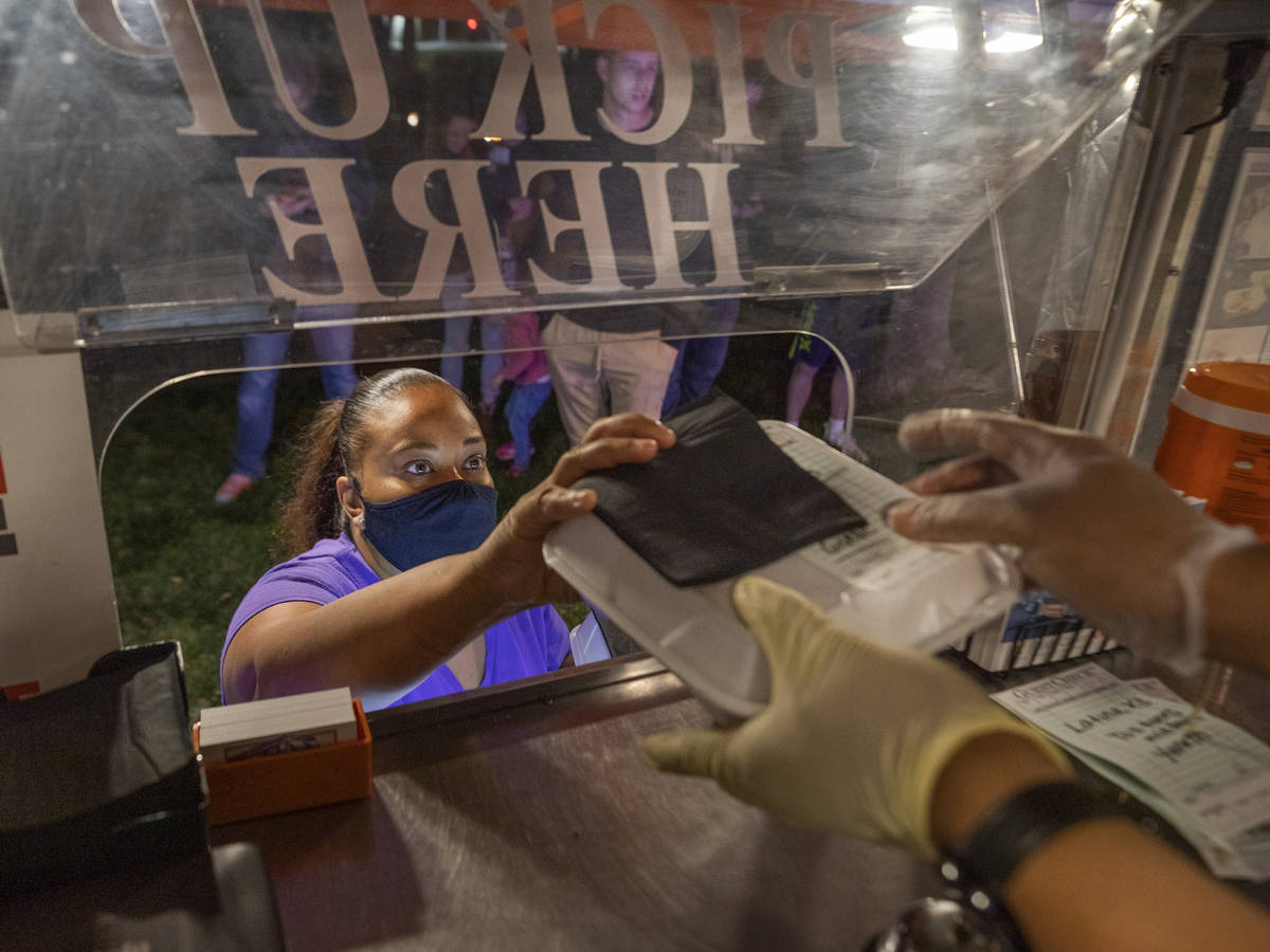 Owner Jinelle Batista picks up a customer's order from YourPanadas empanada truck, during a sto ...