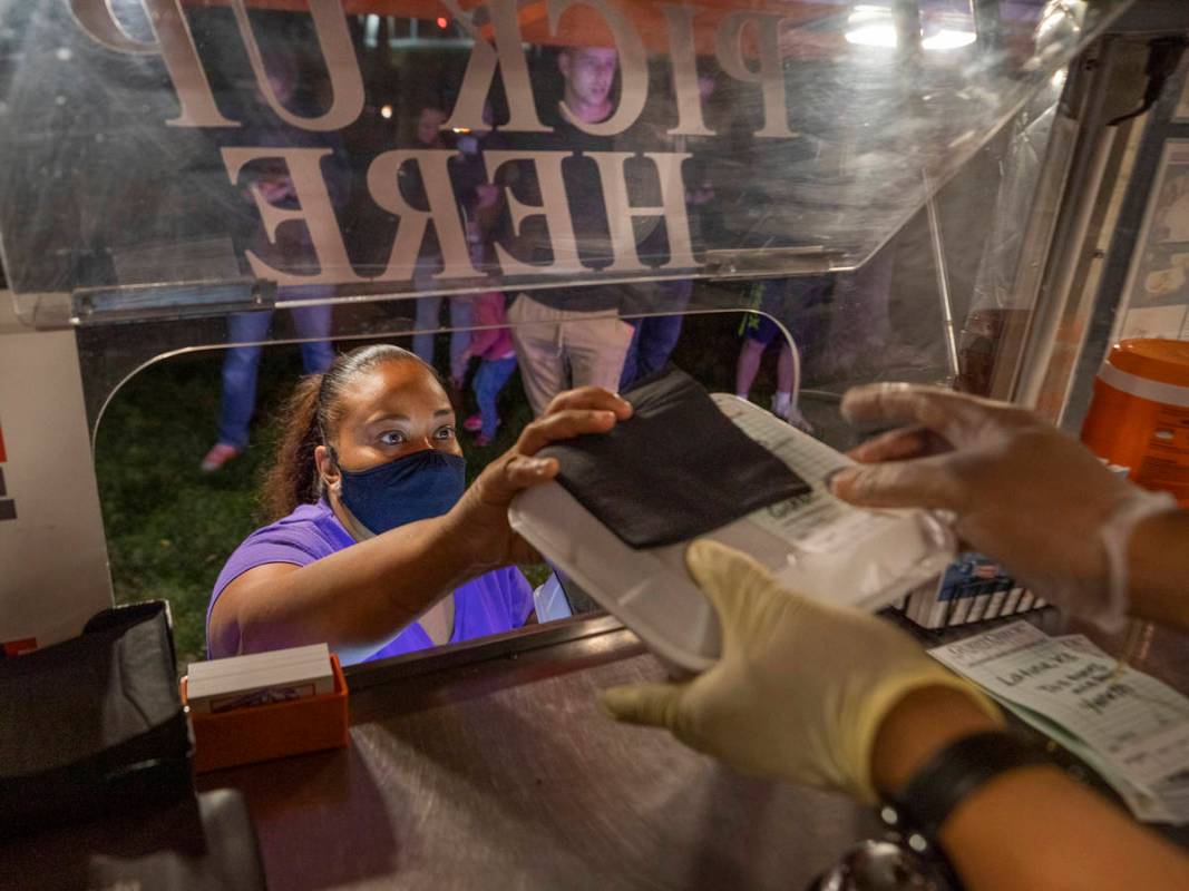 Owner Jinelle Batista picks up a customer's order from YourPanadas empanada truck, during a sto ...