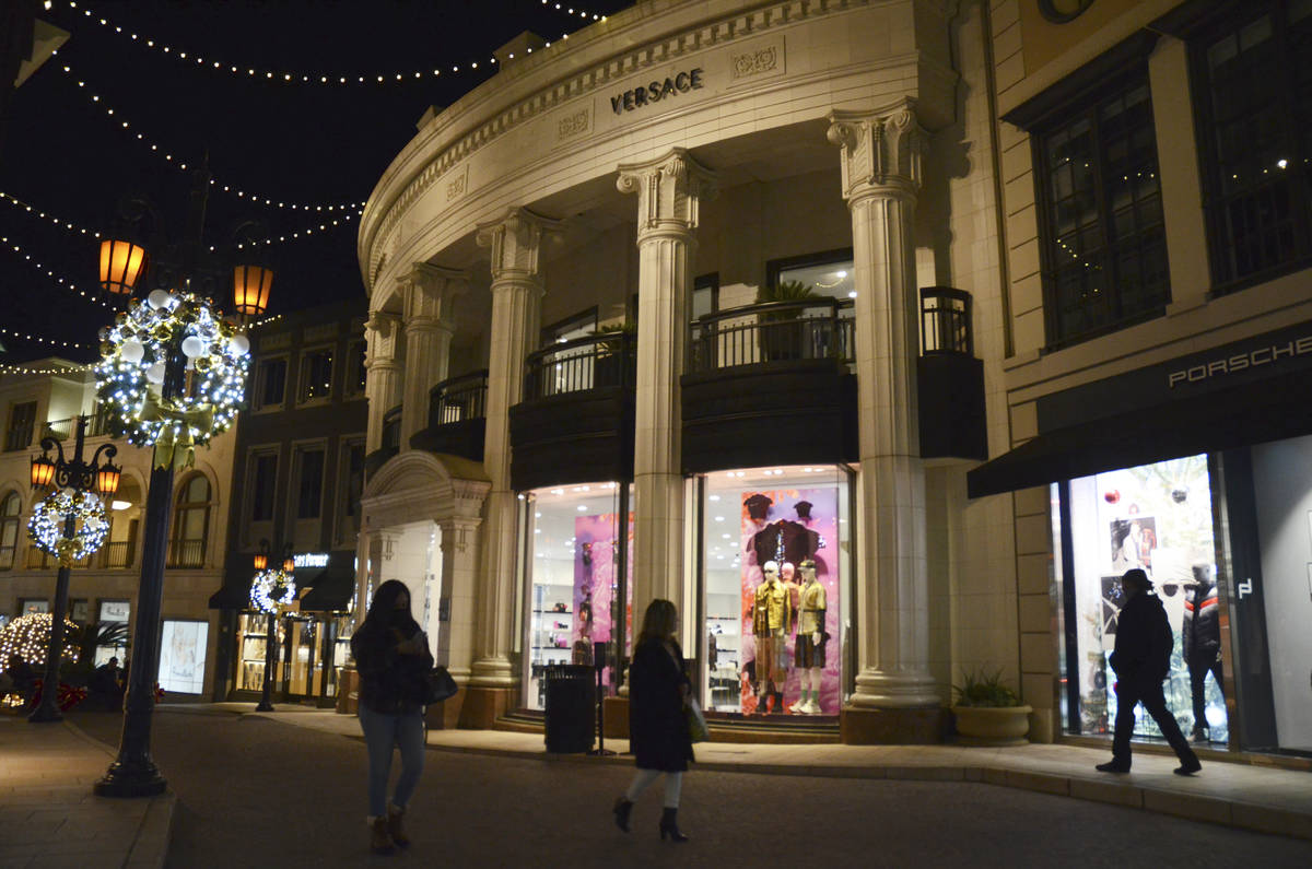 People walk near the Versace boutique on Rodeo Drive, decorated for the holidays amid the coron ...