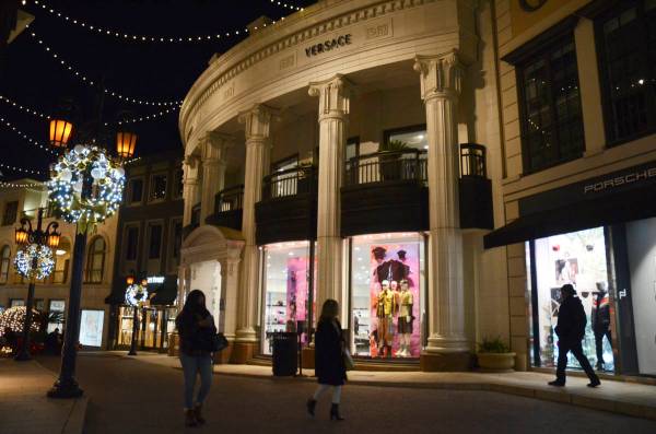 People walk near the Versace boutique on Rodeo Drive, decorated for the holidays amid the coron ...