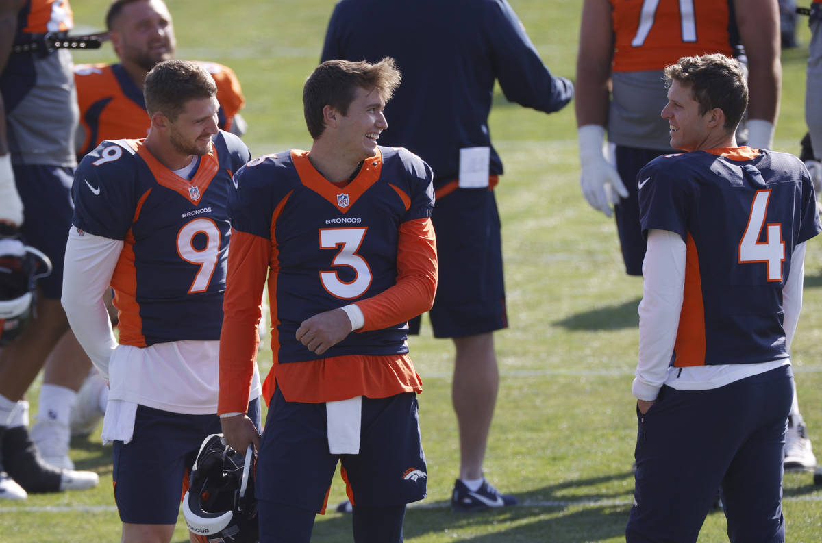 Denver Broncos quarterback Drew Lock, center, jokes with backup quarterbacks Jeff Driskel, left ...