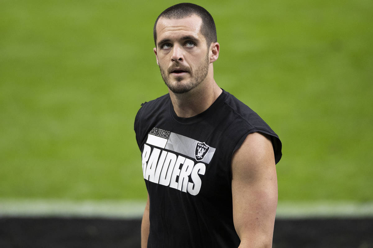 Las Vegas Raiders quarterback Derek Carr warms up before the start of an NFL football game agai ...