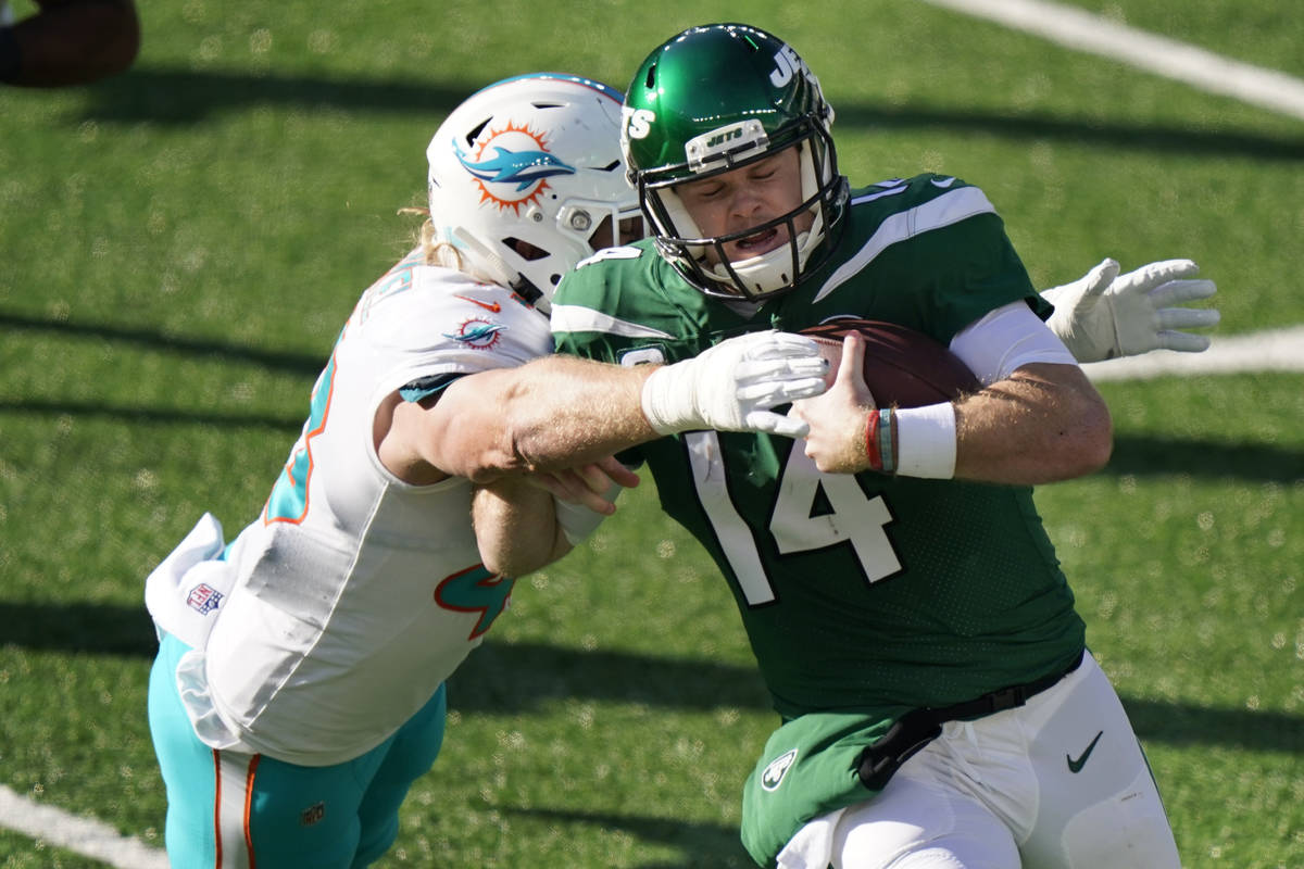 Miami Dolphins' Andrew Van Ginkel, left, tackles New York Jets quarterback Sam Darnold during t ...