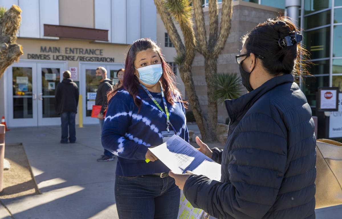 Nevada Department of Motor Vehicles employee Alma Katschke, left, assists Faith Tominaga with p ...