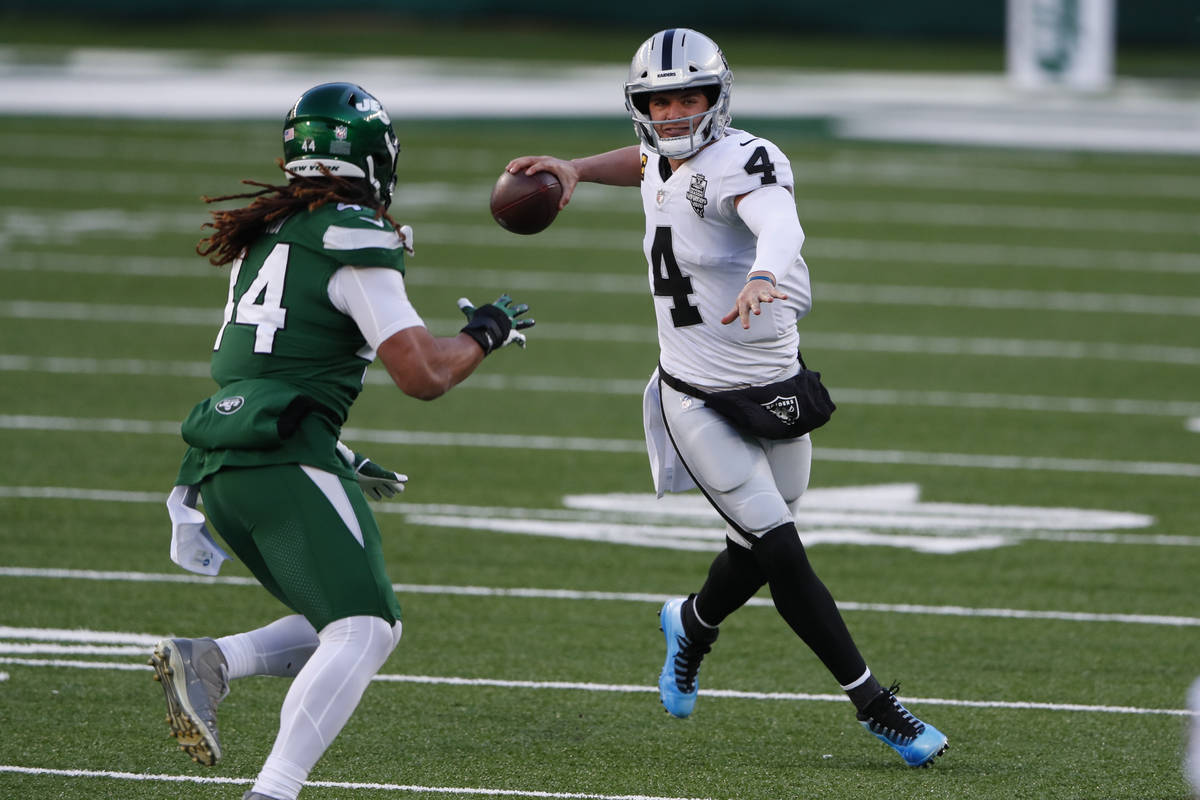 Las Vegas Raiders quarterback Derek Carr, right, looks to throw during the first half an NFL fo ...