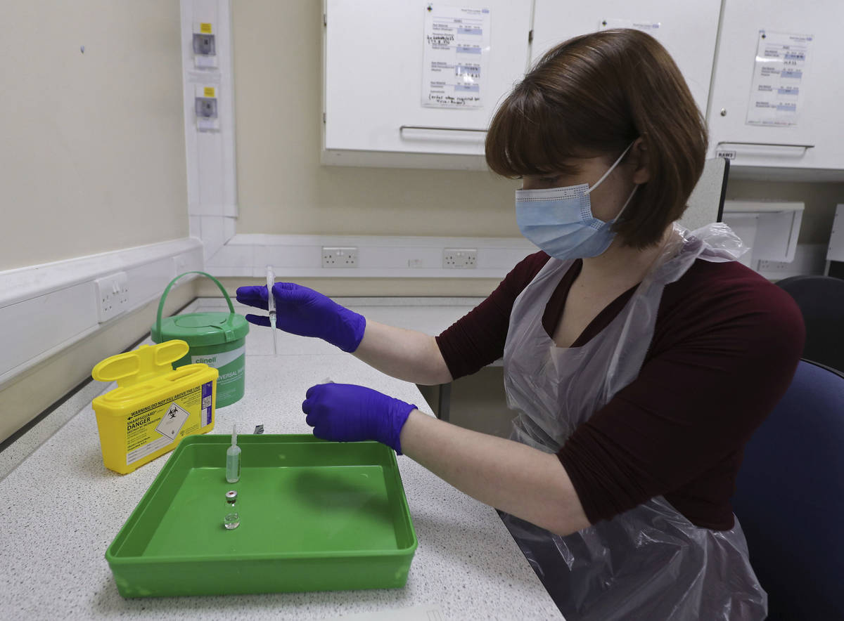 A NHS pharmacy technician at the Royal Free Hospital, simulates the preparation of the Pfizer v ...