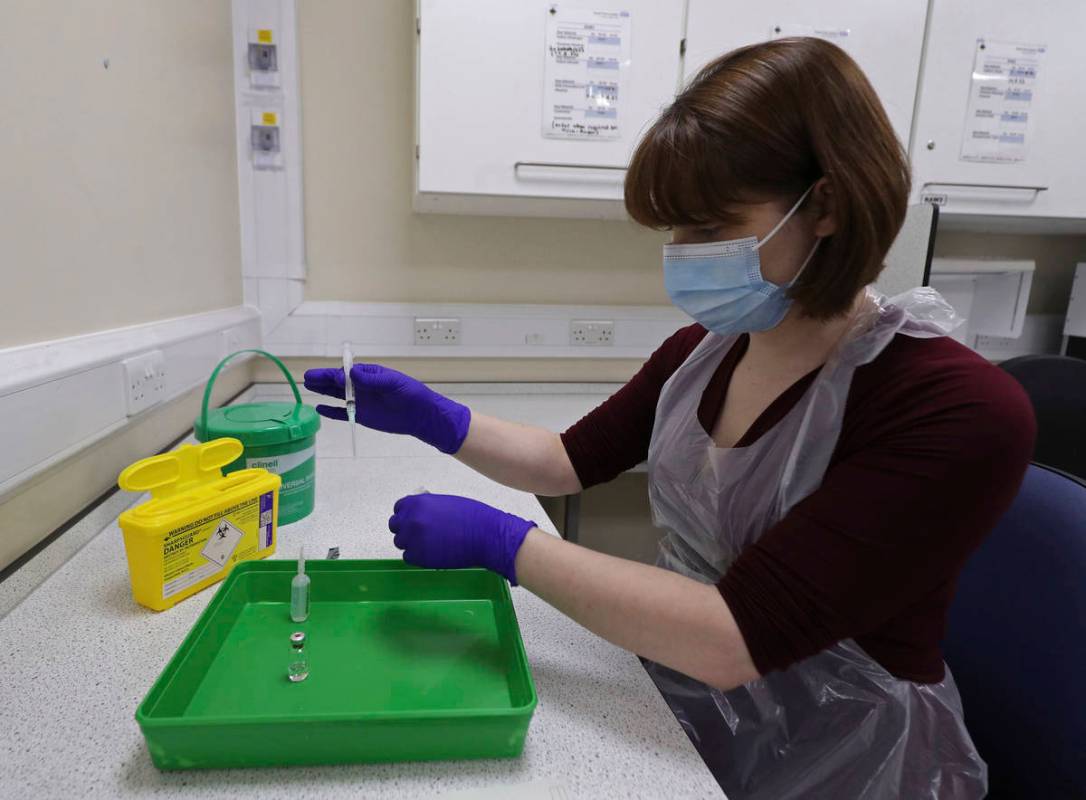 A NHS pharmacy technician at the Royal Free Hospital, simulates the preparation of the Pfizer v ...