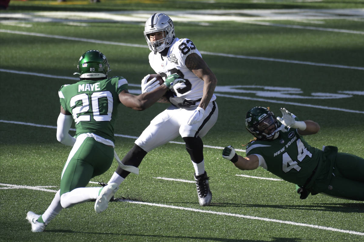 Las Vegas Raiders' Darren Waller, center, avoids New York Jets defenders during the first half ...