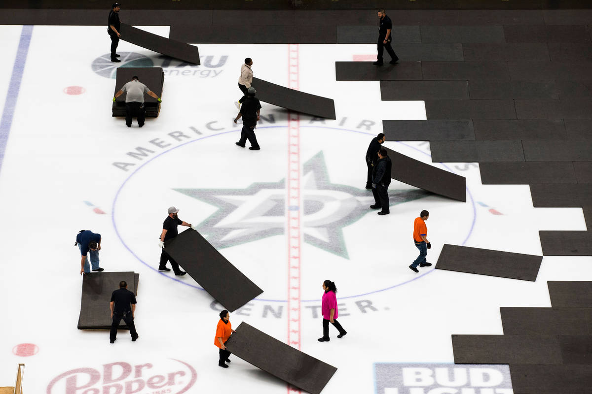 Crews cover the ice at American Airlines Center in Dallas, home of the Dallas Stars hockey team ...