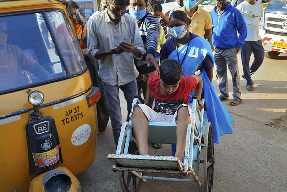A young patient is brought in a wheelchair to the district government hospital in Eluru, Andhra ...