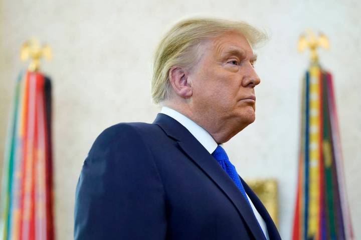 President Donald Trump listens to a reporter's question in the Oval Office of the White House, ...