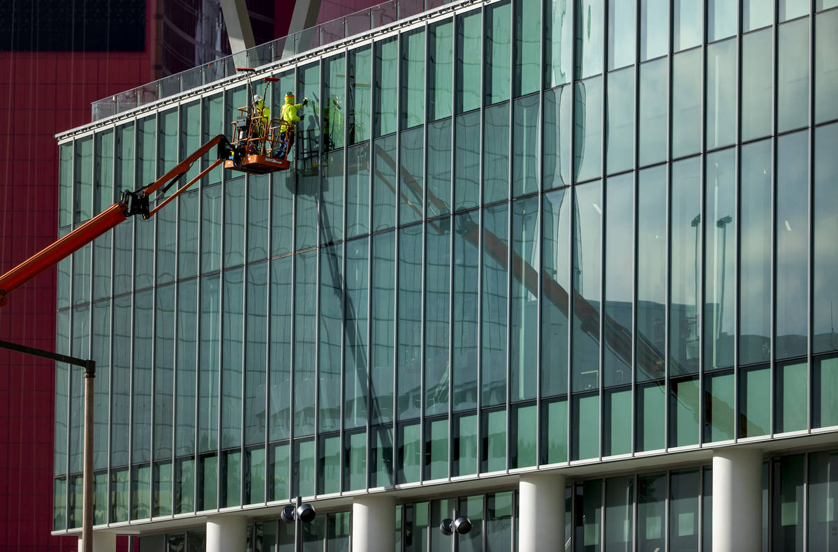 Workers clean the windows out front as construction continues about the new Las Vegas Conventio ...
