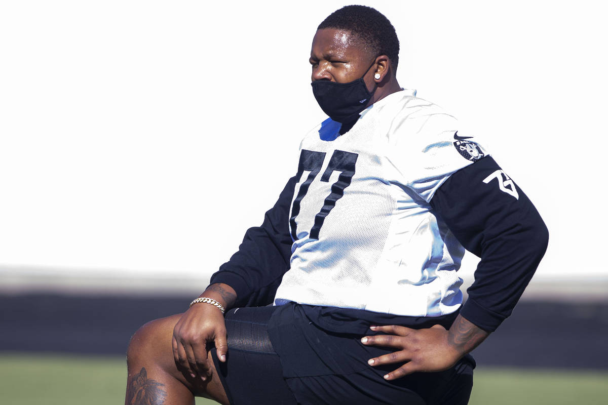 Las Vegas Raiders offensive tackle Trent Brown (77) stretches with a mask on during a practice ...