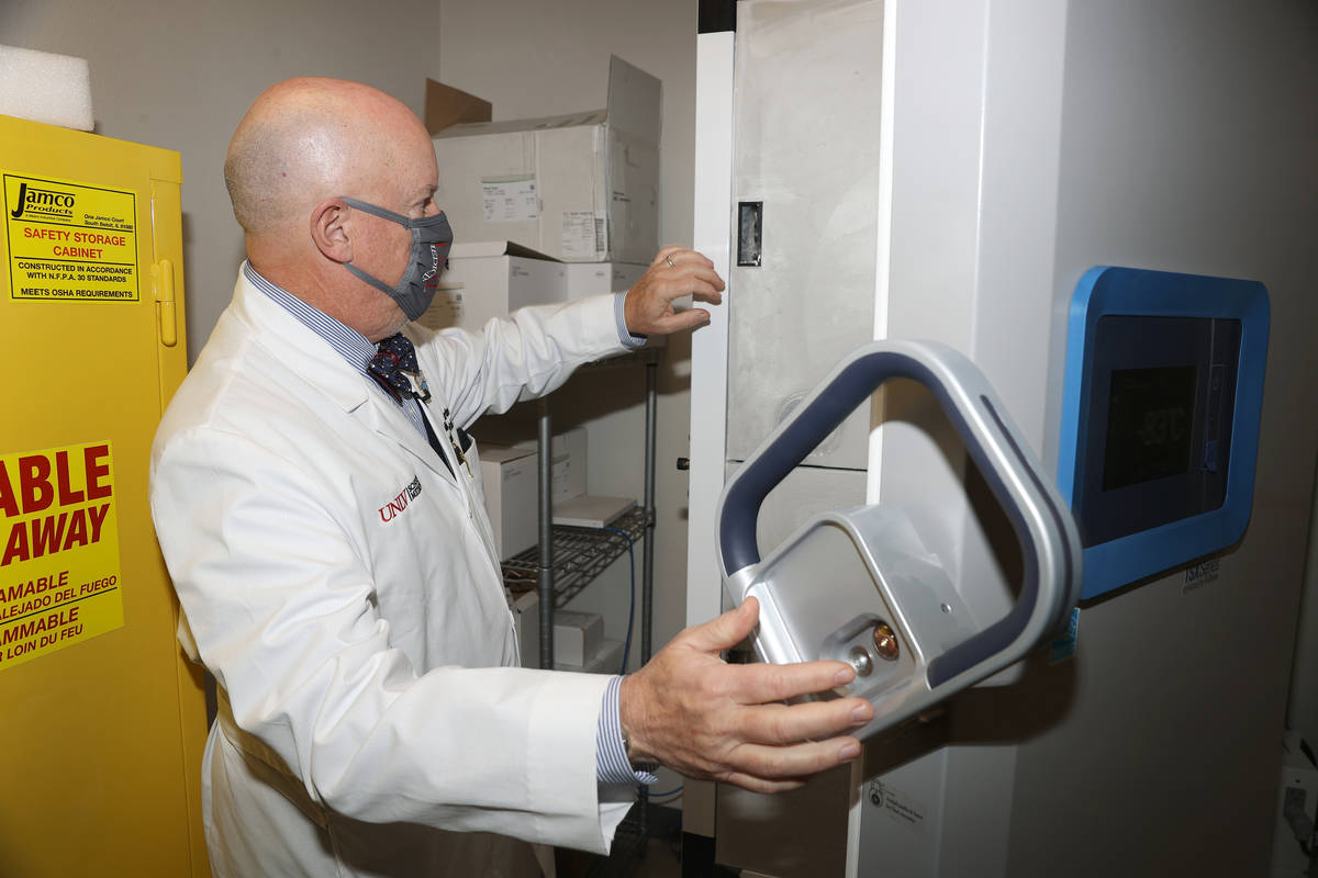 Dr. Michael Gardner opens a freezer that will be used to store COVID-19 vaccines, in Las Vegas ...