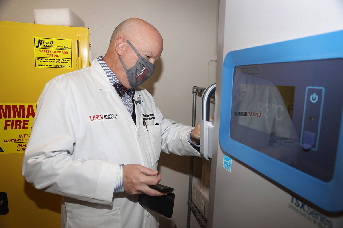Dr. Michael Gardner opens a freezer that will be used to store COVID-19 vaccines, in Las Vegas ...