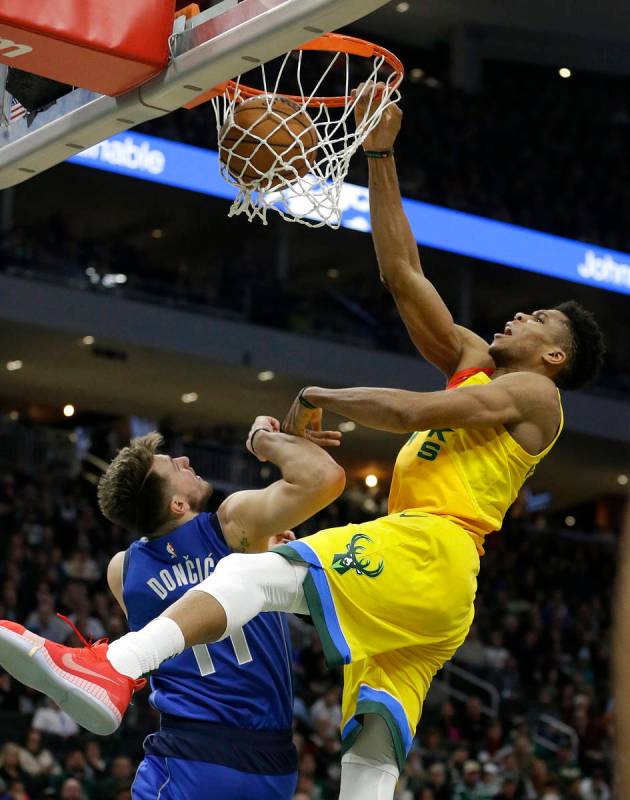 Milwaukee Bucks' Giannis Antetokounmpo dunks against Dallas Mavericks' Luka Doncic during the s ...