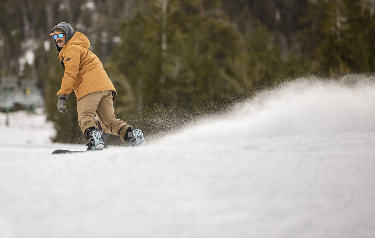 Snowboarder Ian Ryan of Las Vegas glides down the run near the lodge during opening day of skii ...