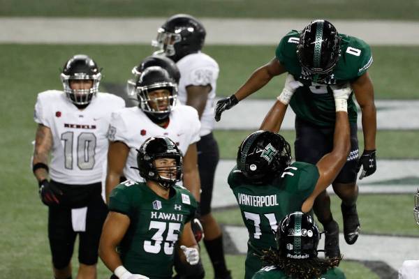 Hawaii running back Dae Dae Hunter (0) is lifted by offensive lineman Micah Vanterpool (71) aft ...