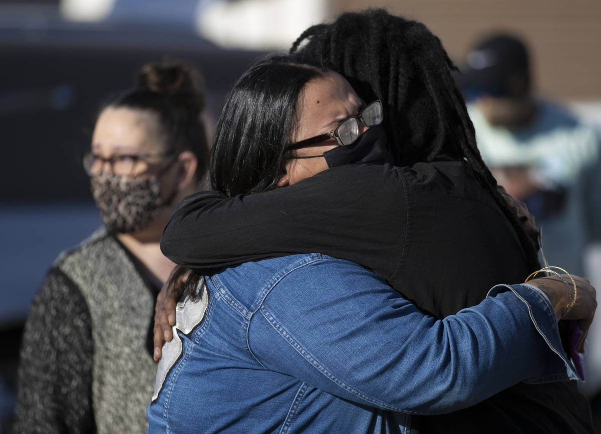 Friends and family grieve outside Hites Funeral Home and Crematory during a memorial service fo ...