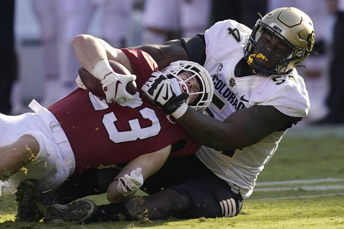 Colorado defensive end Terrance Lang, right, tackles Stanford running back Casey Filkins during ...