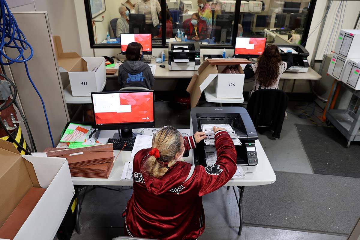 County Election Department staff work on the recount in the Commission District C race between ...