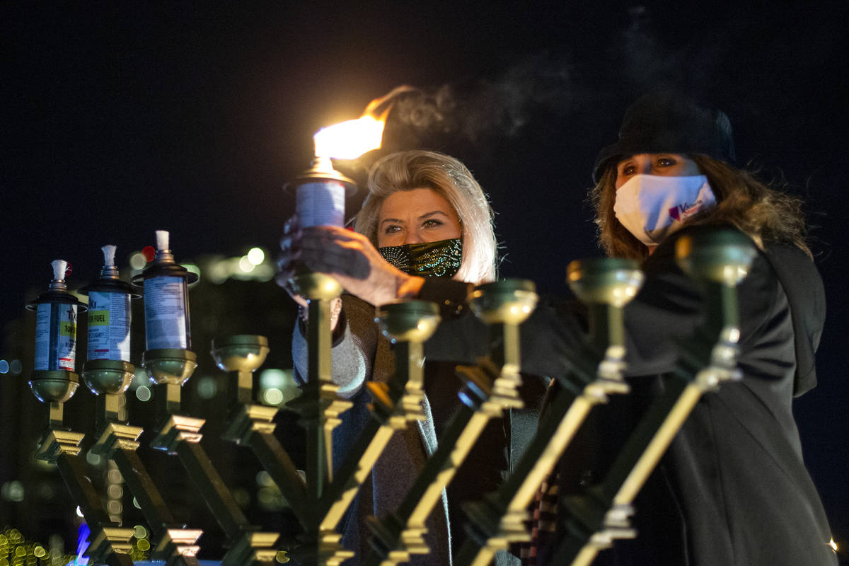 Las Vegas Councilwomen Michele Fiore and Victoria Seaman light the menorah during a drive-in Ha ...