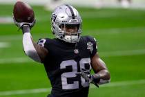 Raiders running back Josh Jacobs (28) throws the football before an NFL football game against t ...
