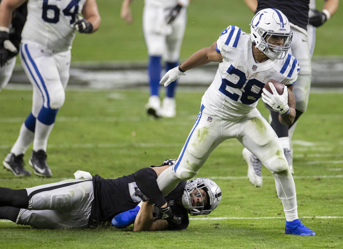 Indianapolis Colts running back Jonathan Taylor (28) fights for extra yardage as Raiders strong ...
