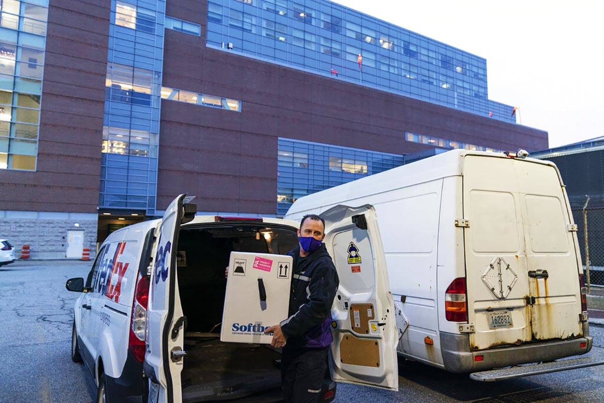 A FedEx driver delivers a box containing the Pfizer-BioNTech COVID-19 vaccine to Rhode Island H ...