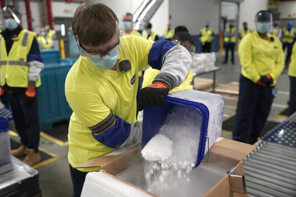 Dry ice is poured into a box containing the Pfizer-BioNTech COVID-19 vaccine as it is prepared ...