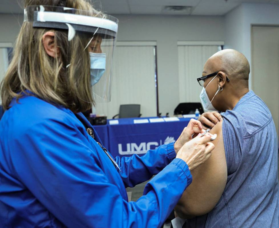 University Medical Center Employee Health Nurse Lori Conti administers a COVID-19 vaccine to UM ...