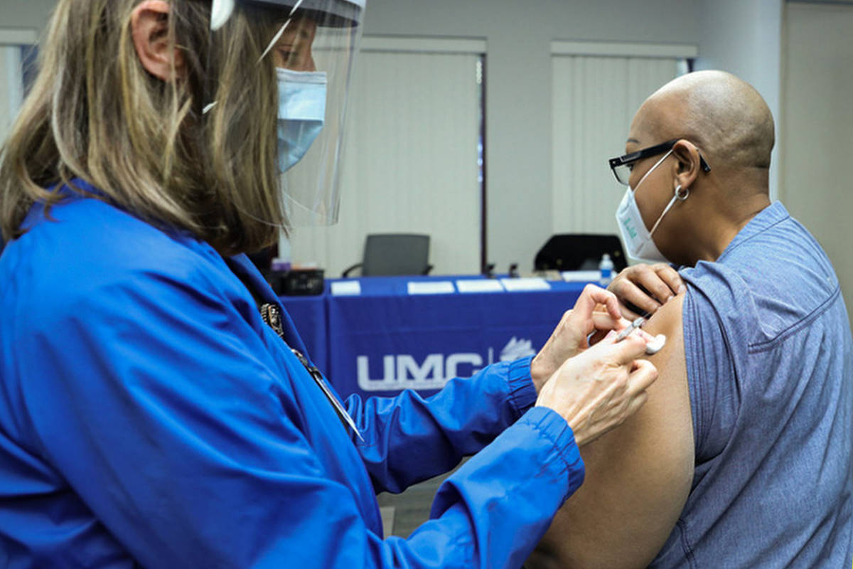 University Medical Center Employee Health Nurse Lori Conti administers a COVID-19 vaccine to UM ...