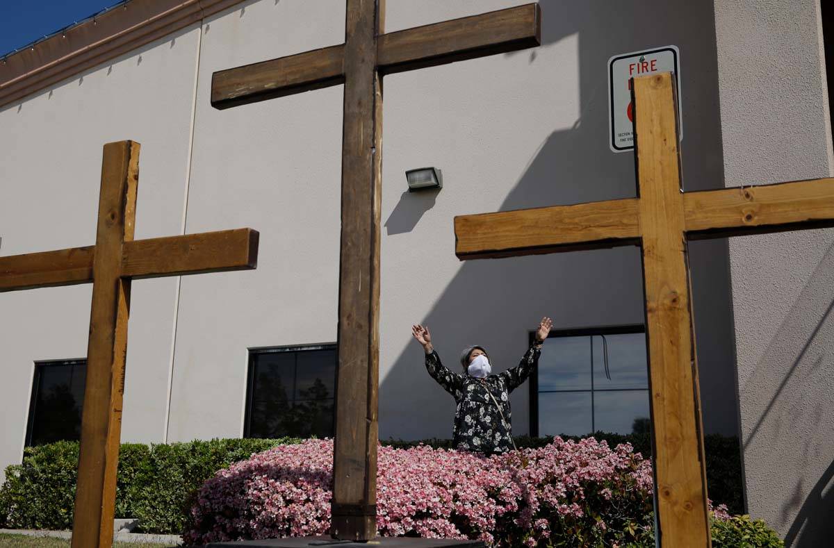 In this April 12, 2020, file photo, Norma Urrabazo prays while wearing a face mask before speak ...