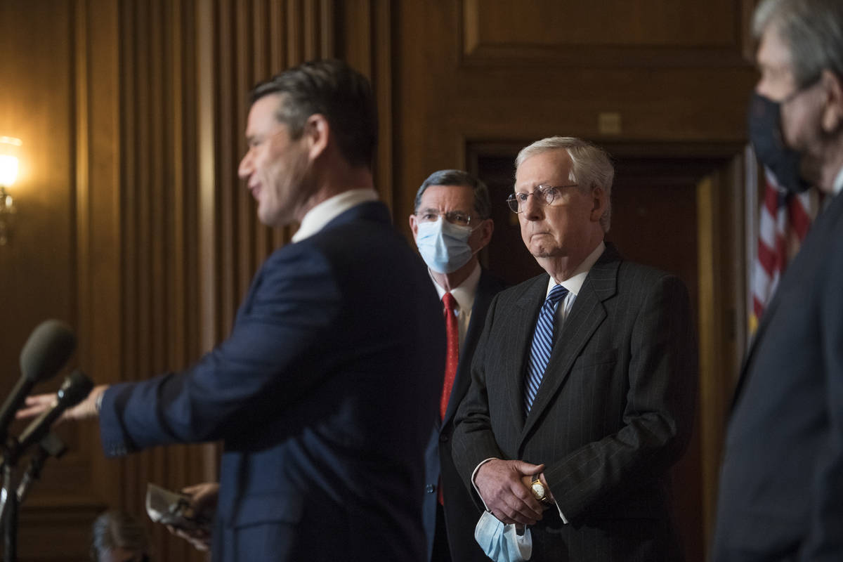 Senate Majority Leader Mitch McConnell of Ky., listens as Sen. Todd Young, R-Ind., speaks durin ...