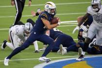 Los Angeles Chargers quarterback Justin Herbert (10) rushes past Las Vegas Raiders strong safet ...