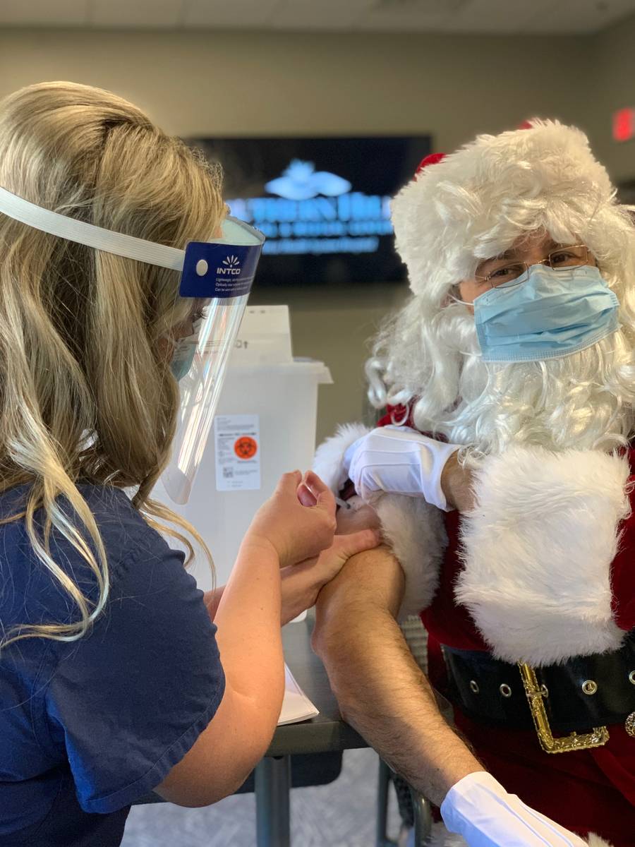 Santa sits for his COVID-19 Pfizer vaccination from nurse Karla Bee at Southern Hills Hospital ...