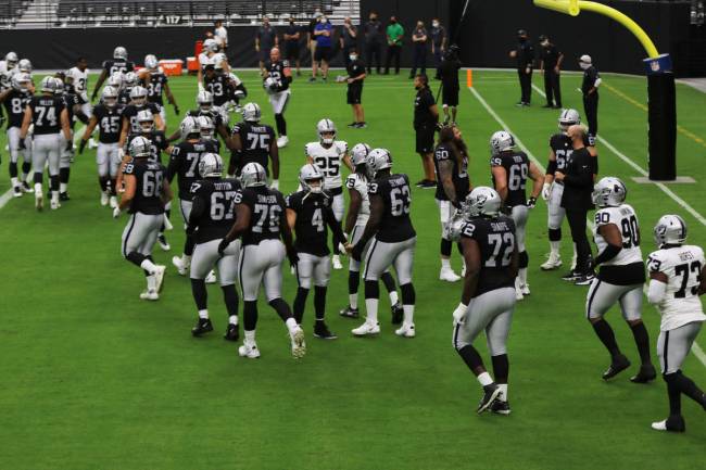 Las Vegas Raiders quarterback Derek Carr (4) greets his teammates as the come through the tunne ...