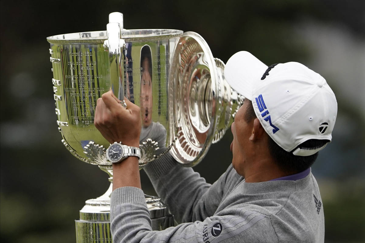 Collin Morikawa reacts as the top of the Wanamaker Trophy falls after winning the PGA Champions ...