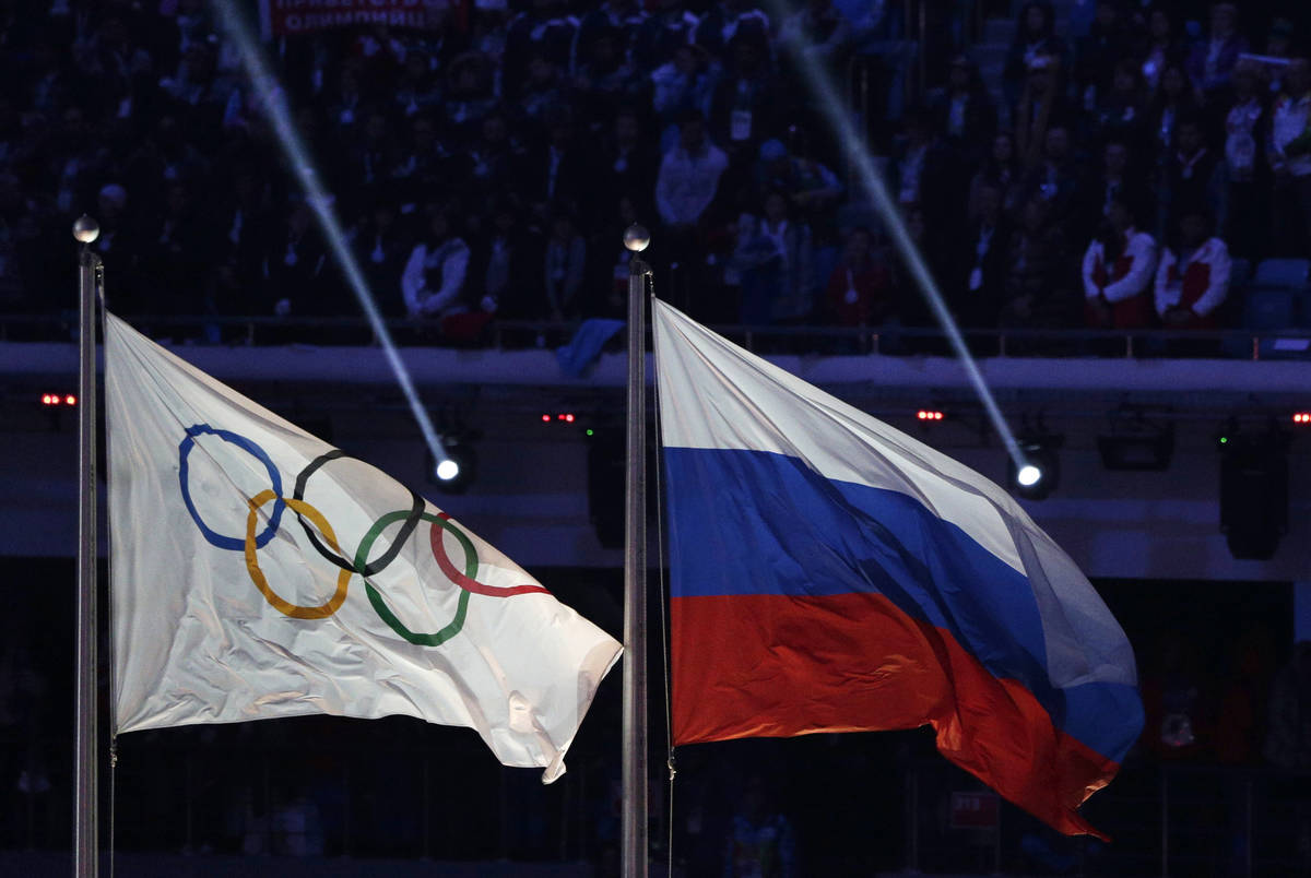 In this Feb. 23, 2014, file photo the Russian national flag, right, flies after it is hoisted n ...