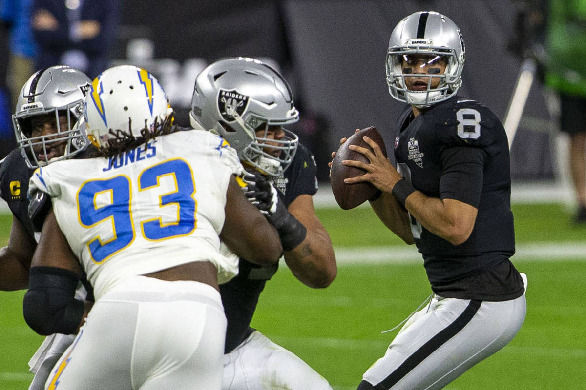 Raiders quarterback Marcus Mariota (8) drops back to pass as Los Angeles Chargers defensive tac ...