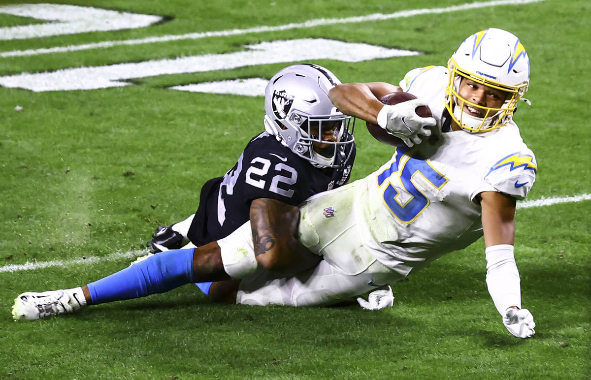 Los Angeles Chargers wide receiver Jalen Guyton (15) gets tackled by Raiders cornerback Keisean ...