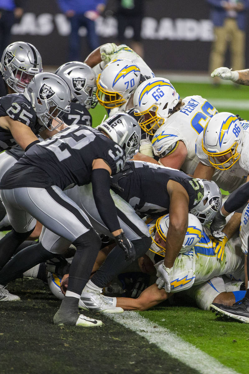 Los Angeles Chargers quarterback Justin Herbert (10) reaches into the end zone to score the gam ...